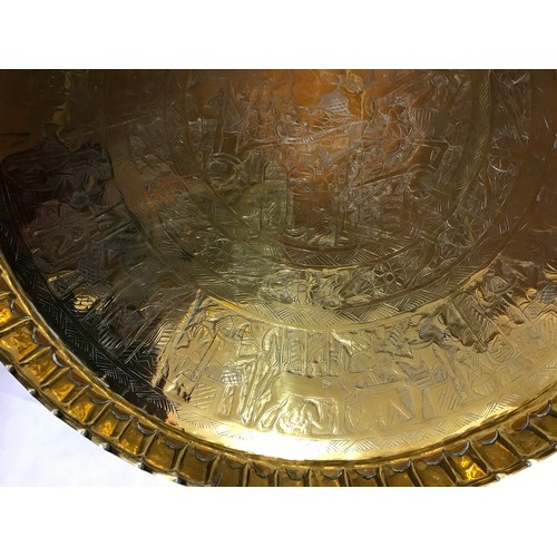 817 - A large brass table top with Egyptian style decoration measuring 61cm in diameter along with a brass... 