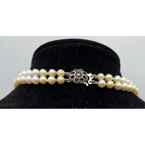 450 - A double strand cultured pearl necklace with silver clasp together with a long cultured pearl neckla... 