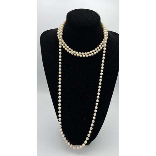 450 - A double strand cultured pearl necklace with silver clasp together with a long cultured pearl neckla... 