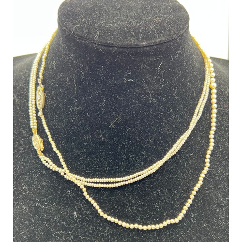 457 - Two seed pearl necklaces, one double row, one single, both with yellow metal and diamond set clasps,... 