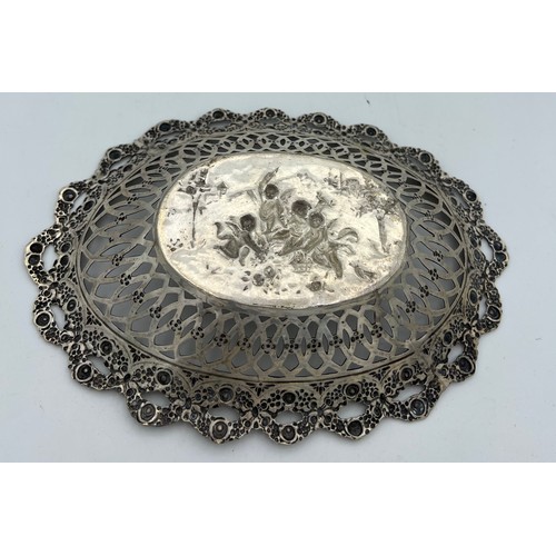 705 - German silver oval dish depicting cherubs at play with pierced border. Size 20.5 x 14.5cm.  Weight 1... 