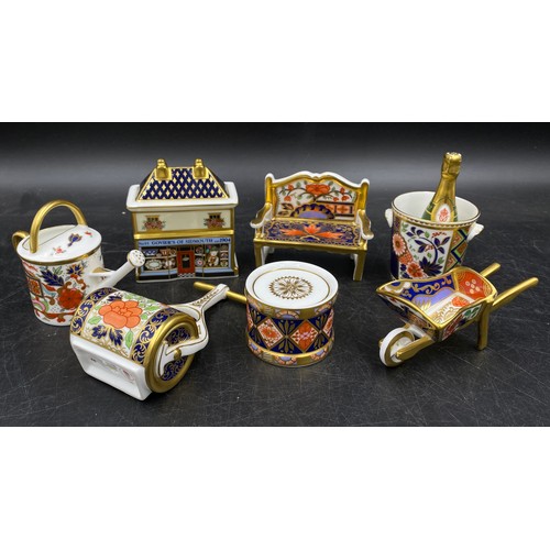 167 - A group of Royal Crown Derby porcelain miniature items, comprising toy drum with drumsticks, champag... 