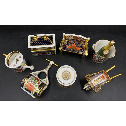 167 - A group of Royal Crown Derby porcelain miniature items, comprising toy drum with drumsticks, champag... 