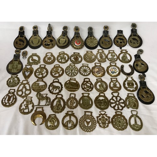 818 - A collection of horse brasses some on leather straps and some individual.