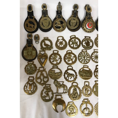 818 - A collection of horse brasses some on leather straps and some individual.