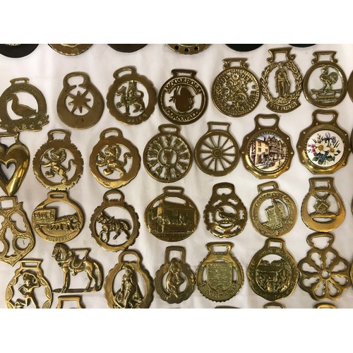 818 - A collection of horse brasses some on leather straps and some individual.