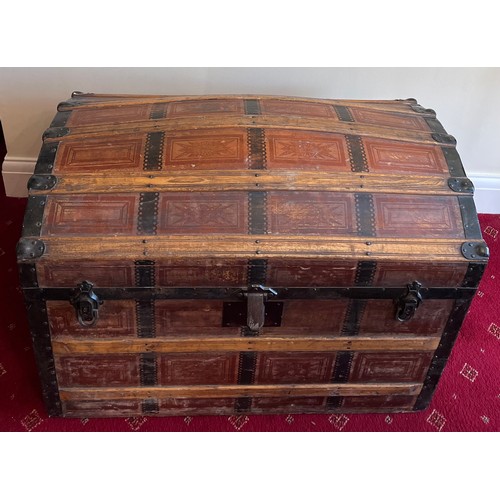 25 - A 19thC dome topped wooden bound trunk with metal fittings and leather carrying handles. 88 w x 50 d... 