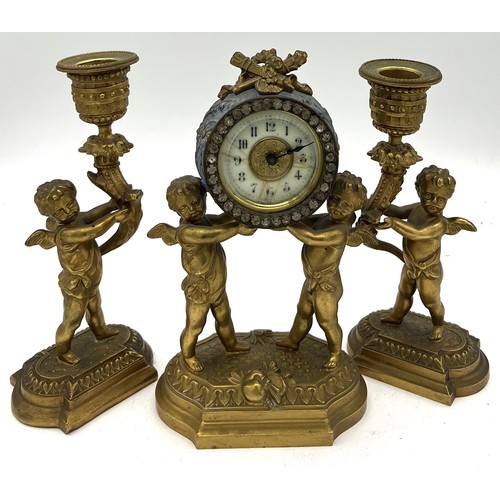 1021 - Ormolu clock garniture. 20cm h. Two cherub candlesticks and clock with enamelled face.