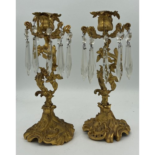 1022 - A pair of ormolu candlesticks with crystal drops. 26cm h.