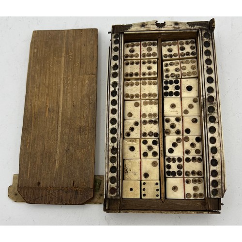 1024 - A Napoleonic prisoner of war box containing dominoes and two dice. Painted scenes to top. 15 x 8cm. ... 