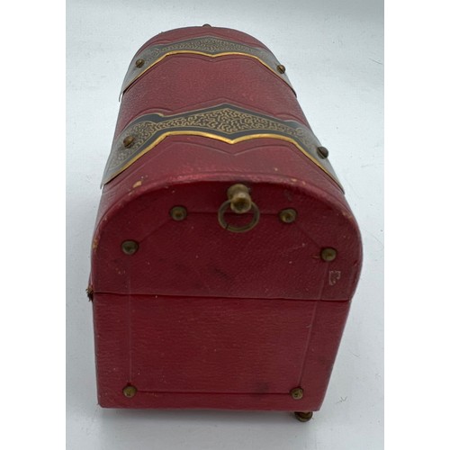 1043 - Red leather covered casket containing two glass and gilt metal scent bottles with painted tops and i... 