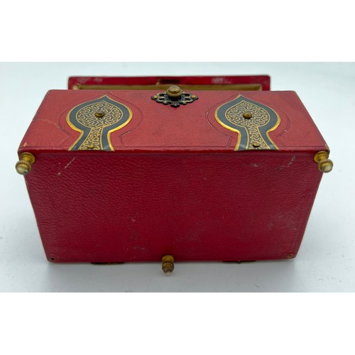 1043 - Red leather covered casket containing two glass and gilt metal scent bottles with painted tops and i... 