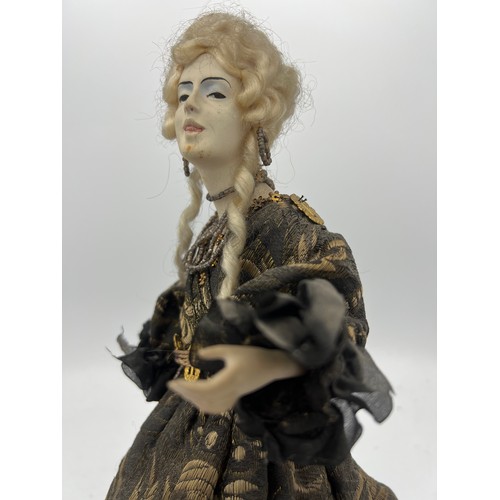 1064 - A 19thC doll with bisque heads and arms on a weighted base. 32cm h.