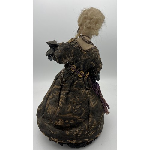 1064 - A 19thC doll with bisque heads and arms on a weighted base. 32cm h.