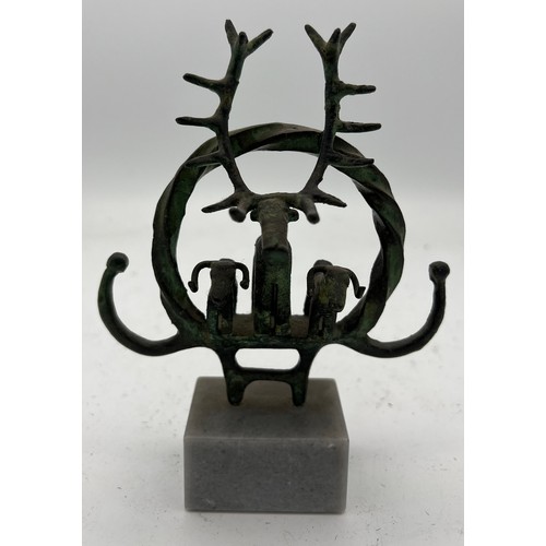 1065 - An Anatolian bronze ceremonial standard on marble depicting a stag and two bulls in a twisted hoop. ... 