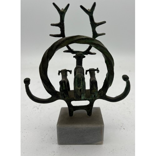 1065 - An Anatolian bronze ceremonial standard on marble depicting a stag and two bulls in a twisted hoop. ... 