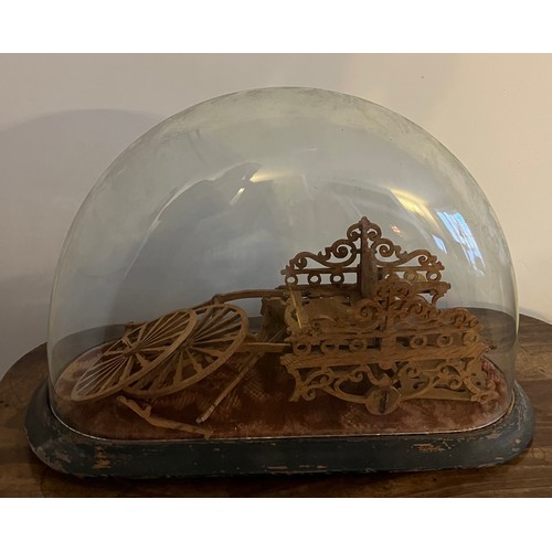 1072 - A wooden fretwork cart under a glass dome on wooden base.  43w x 18cm d.