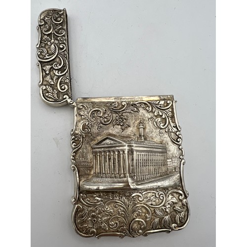 717 - A Victorian silver castle-top card case. The Royal Exchange London in high relief with a foliage scr... 