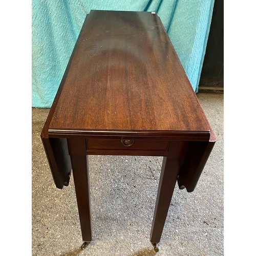 91 - A mahogany drop leaf table with drawer and castors. 74 h x 121 w x 92cm, closed 45cm w.