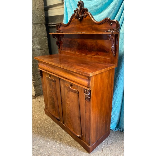 92 - A mahogany chiffonier, carved shaped back with a single shelf raised on scroll supports, above one l... 