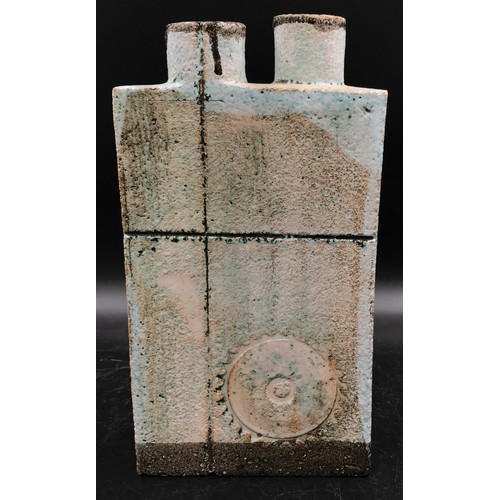 122 - A studio pottery slab vase with two cylindrical openings to the top and a circular pattern engraved ... 