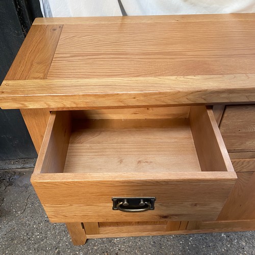 79 - An oak sideboard, three drawers over three doors. 87 h x 149 w x 44cm d.