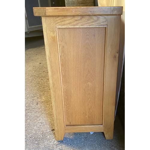 79 - An oak sideboard, three drawers over three doors. 87 h x 149 w x 44cm d.