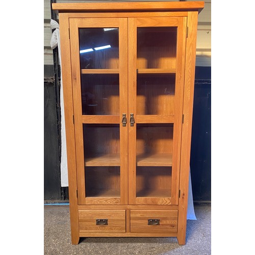 83 - An oak glazed display cabinet/ bookcase with 3 shelves over 2 drawers. 181 h x 100 w x 40cm d.