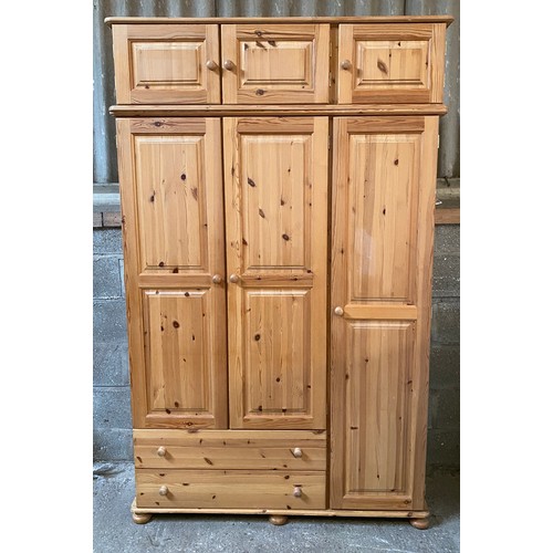 84 - A large pine wardrobe with a combination of three doors over two drawers and a removable 3 cupboard ... 