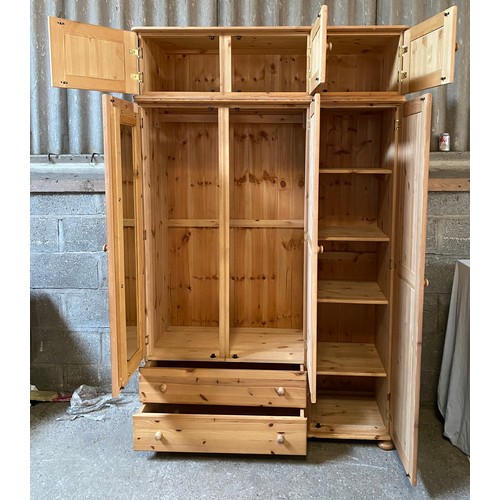 84 - A large pine wardrobe with a combination of three doors over two drawers and a removable 3 cupboard ... 