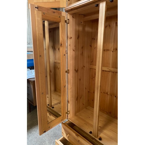 84 - A large pine wardrobe with a combination of three doors over two drawers and a removable 3 cupboard ... 