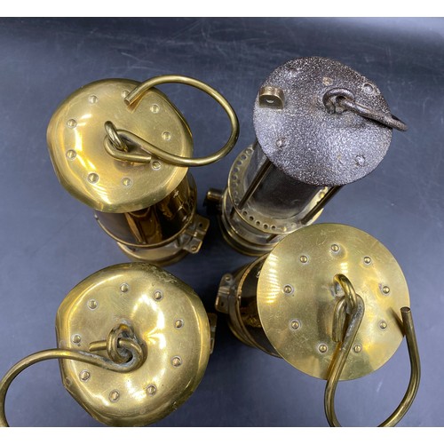 992 - Four miner's lamps, to include three with badge for The Protector Lamp & Lighting Company, each stam... 