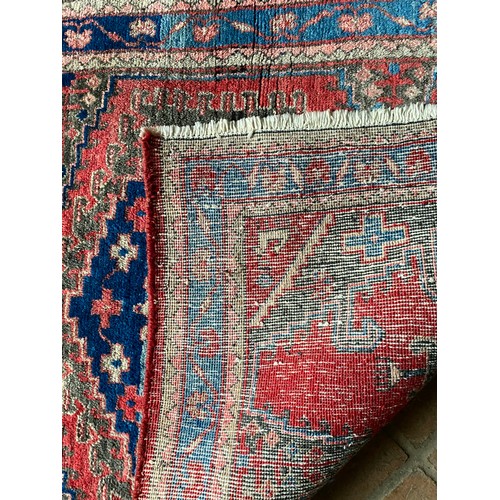 957 - A wool rug with red and blue ground geometric design. 142 x 103cm.