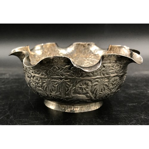 745 - An Indian silver bowl relief embossed decoration depicting elephant, tiger, figure, trees and other ... 