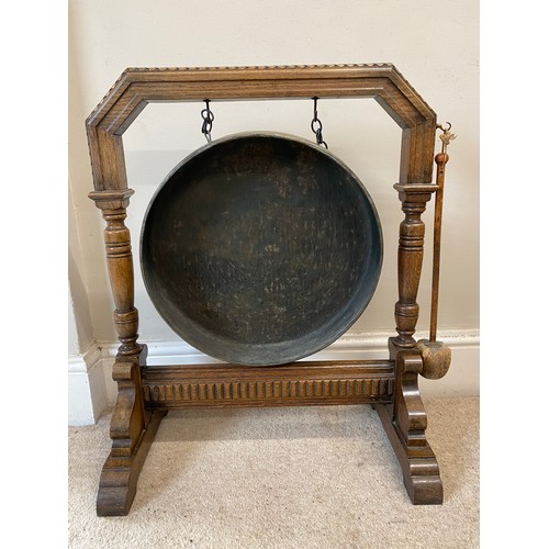 995 - A 20thC large oak dinner gong with striker measuring 71 h x 58 w x 33cm d, brass gong 41cm d.