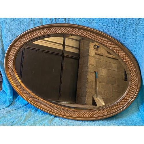 952 - An oval gilt framed mirror. 67 h x 96cm w.