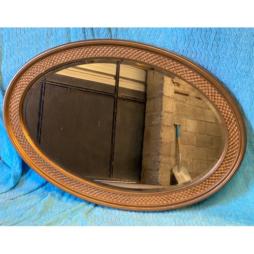 952 - An oval gilt framed mirror. 67 h x 96cm w.