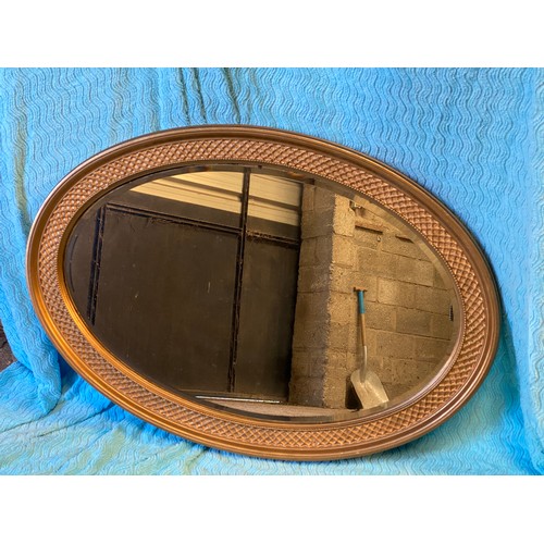 952 - An oval gilt framed mirror. 67 h x 96cm w.