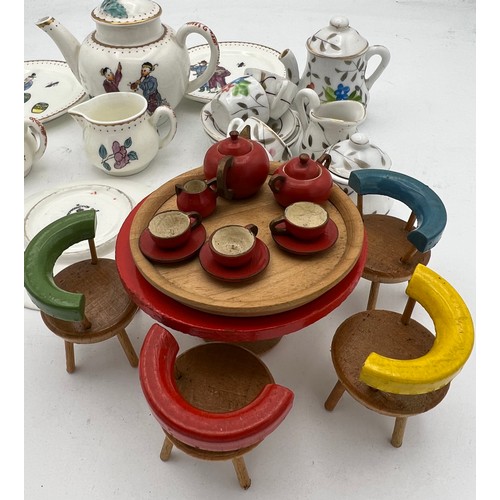 142 - Two miniature tea services and a vintage wooden dolls house table 8cm d, chairs and tea service. 
To... 