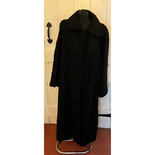 871 - A vintage black astrakhan coat (underarm to underarm approximately 60cm.) with matching hat and silk... 