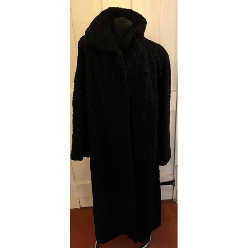 871 - A vintage black astrakhan coat (underarm to underarm approximately 60cm.) with matching hat and silk... 