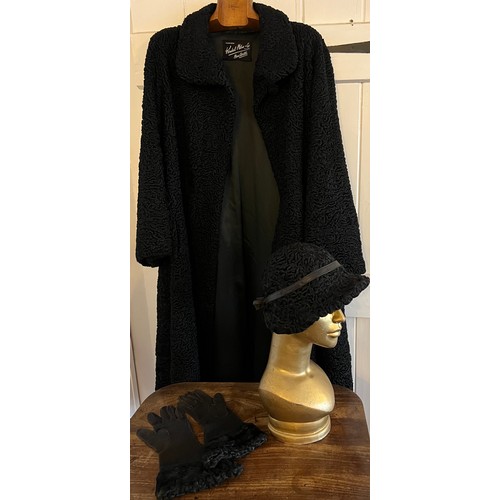 871 - A vintage black astrakhan coat (underarm to underarm approximately 60cm.) with matching hat and silk... 