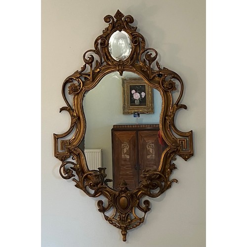 954 - A pair of 18thC ornate carved gilt wood and gesso wall mirrors with two candle sconces. 112cm h x 69... 