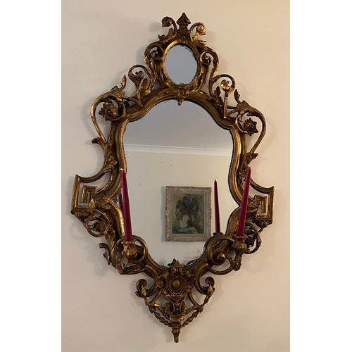 954 - A pair of 18thC ornate carved gilt wood and gesso wall mirrors with two candle sconces. 112cm h x 69... 