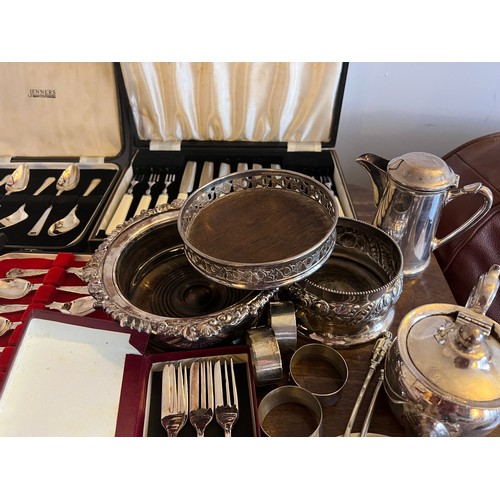 679 - A quantity of silver plated cutlery etc to include boxed spoons, lidded tureen, bottle stands and na... 