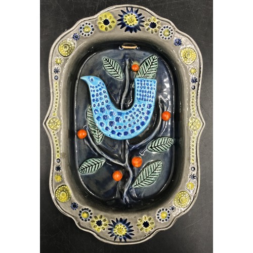 146 - A late 20thC Arklow Pottery wall plaque designed by John F French, relief moulded with a bird in a t... 