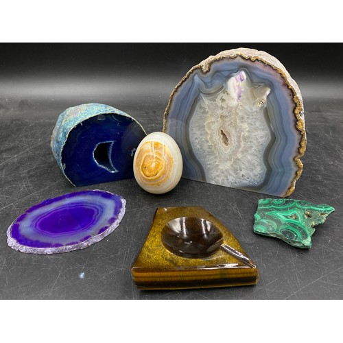 965 - A collection of four dyed agate geodes, varying sizes along with an onyx egg and a stone ashtray.