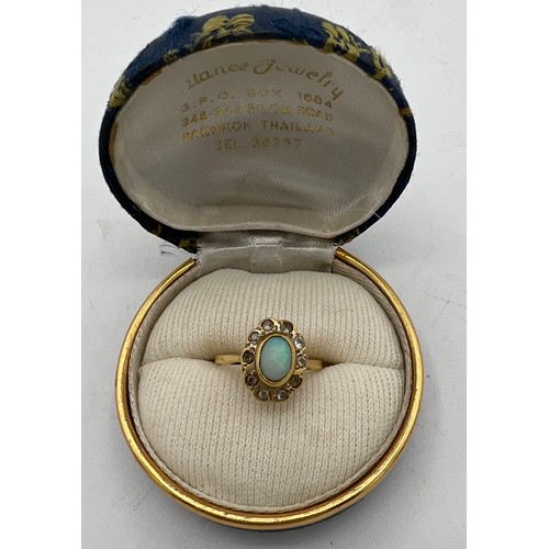 485 - An 18 carat gold ring set with opal and clear stones. Size J. Weight 2.9gm.