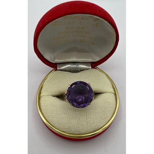 486 - A yellow metal ring marked 14K set with purple stone. Size O. Weight 6.1gm.