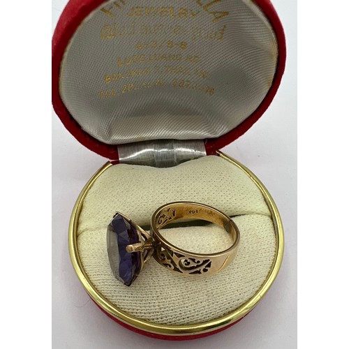 486 - A yellow metal ring marked 14K set with purple stone. Size O. Weight 6.1gm.